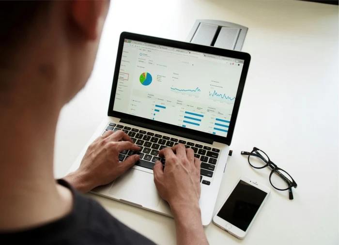 Person using a laptop showing analytics charts on screen